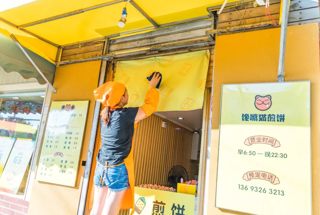 精心维护店面的张姐
