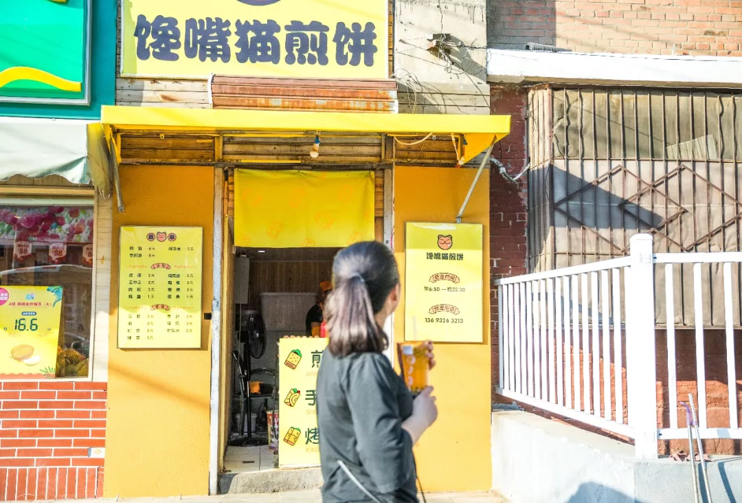 被小店新装扮吸引驻足停留的路人